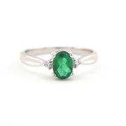Silver ring with a green gemstone on a white background