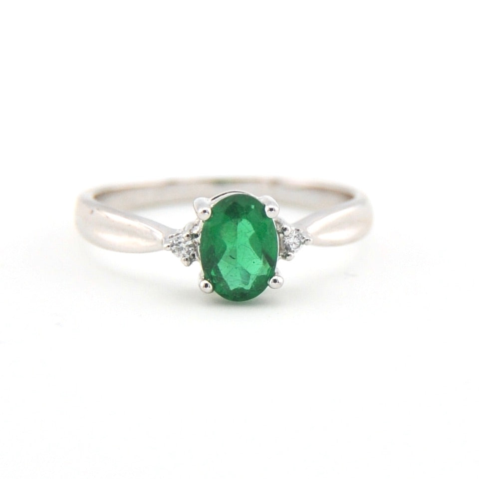 Silver ring with a green gemstone on a white background