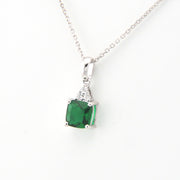Green gemstone pendant on a silver chain against a white background
