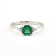 Silver ring with a green gemstone on a white background
