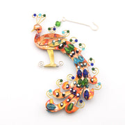 Decorative peacock ornament with colorful beads on a white background