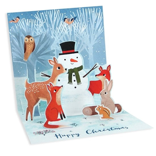 A 3D pop-up Christmas greeting card featuring a winter forest scene with a snowman, deer, fox, rabbit, owl, and squirrel. The card is displayed open against a clean white background, with 'Happy Christmas' written at the bottom.