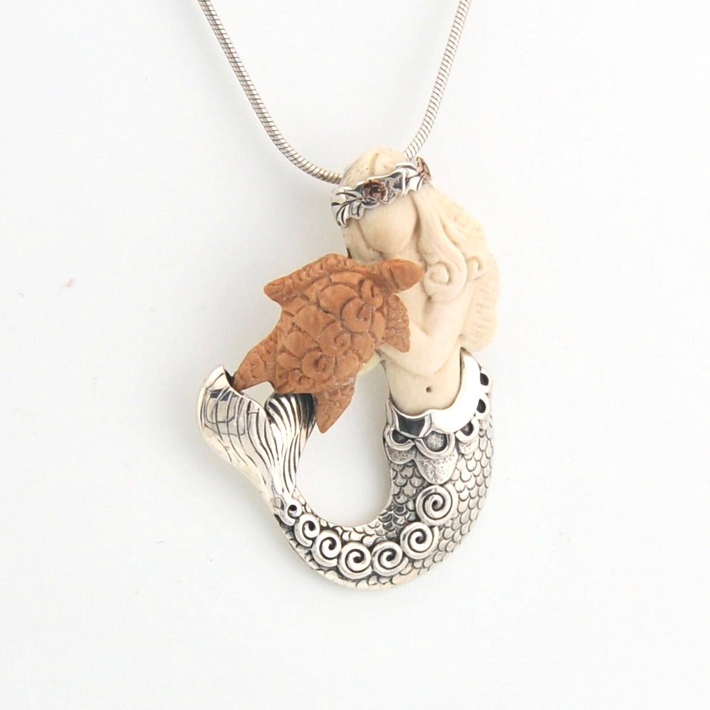 Necklace with a unique pendant featuring a mermaid with turtle on a white background