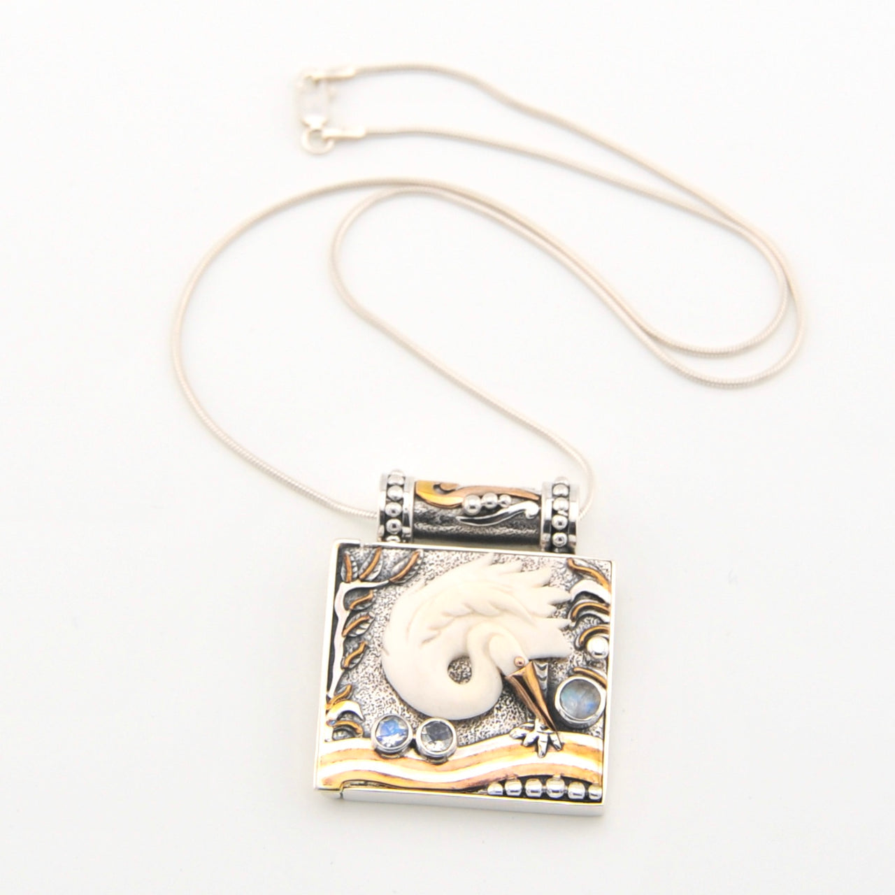 Necklace with a decorative pendant featuring a white dove and blue stones on a white background