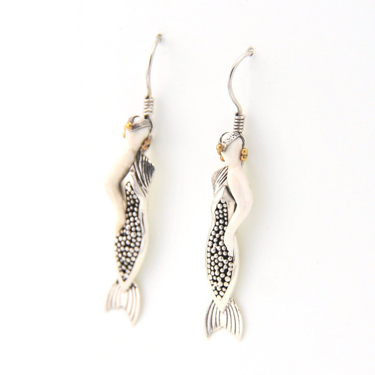 Pair of mermaid earrings with intricate designs on a white background