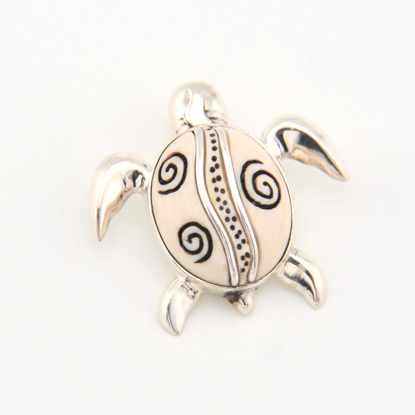 Silver turtle pendant with black patterns on a white background