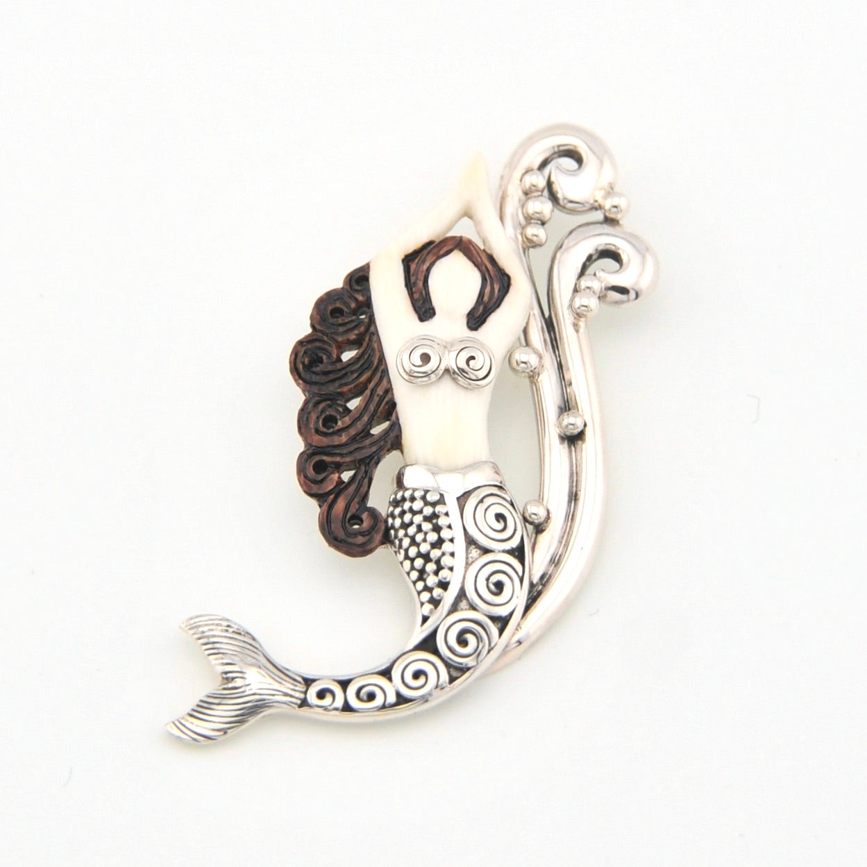 Mermaid-shaped pendant with intricate designs on a white background