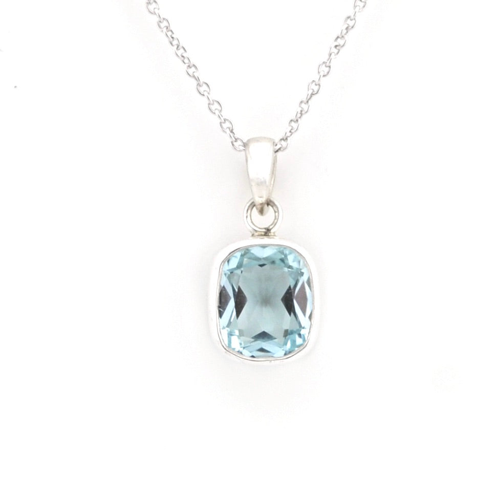 A silver pendant necklace featuring a cushion-cut light blue gemstone, displayed on a clean white background.