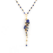 A gold-tone beaded necklace featuring a dangle pendant made of polished lapis lazuli and pyrite beads, shown against a plain white background.