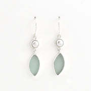 A pair of silver drop earrings featuring a small white pearl and a teardrop-shaped light green stone, shown against a plain white background.