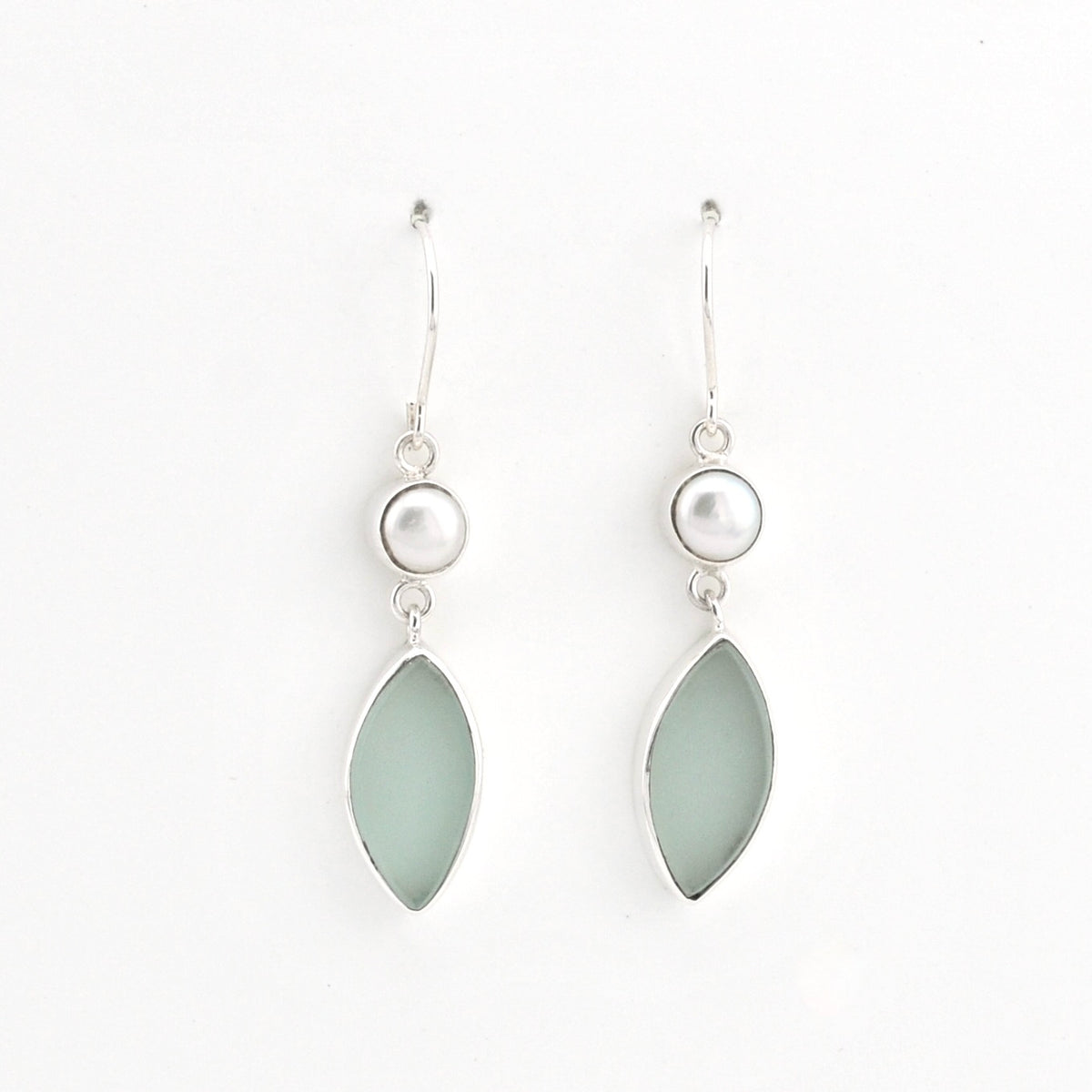 A pair of silver drop earrings featuring a small white pearl and a teardrop-shaped light green stone, shown against a plain white background.
