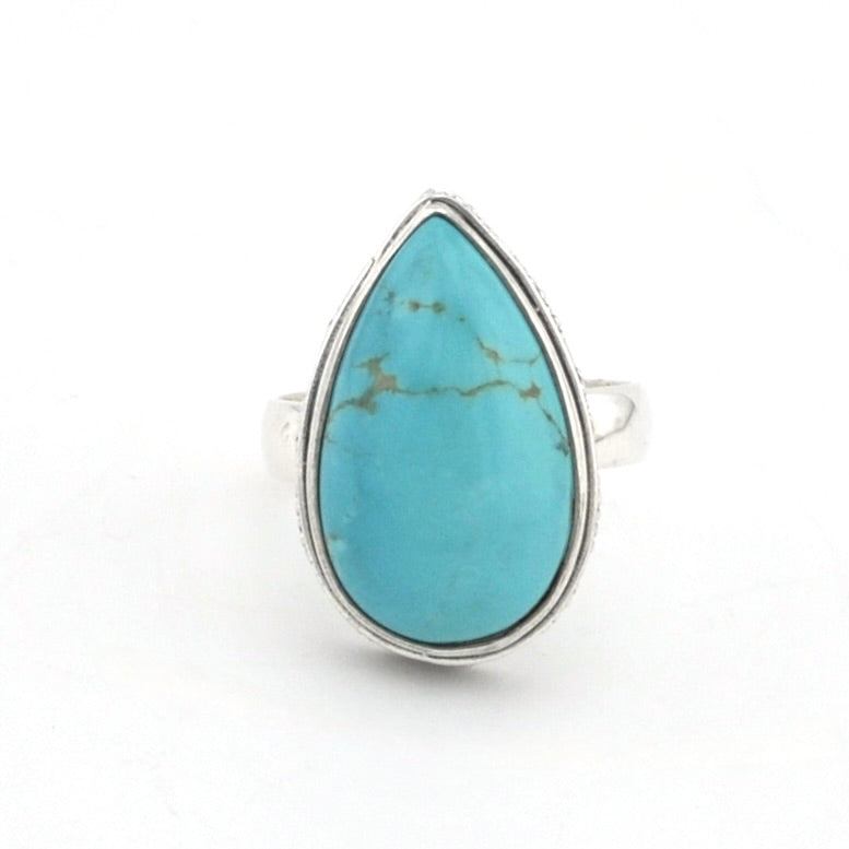 Silver ring with tear shaped turquoise on white background.