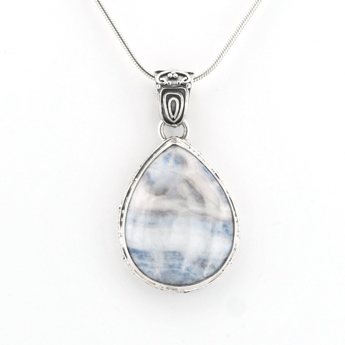 A silver teardrop pendant necklace featuring a marbled blue and white stone, suspended from a delicate silver chain against a plain white background.