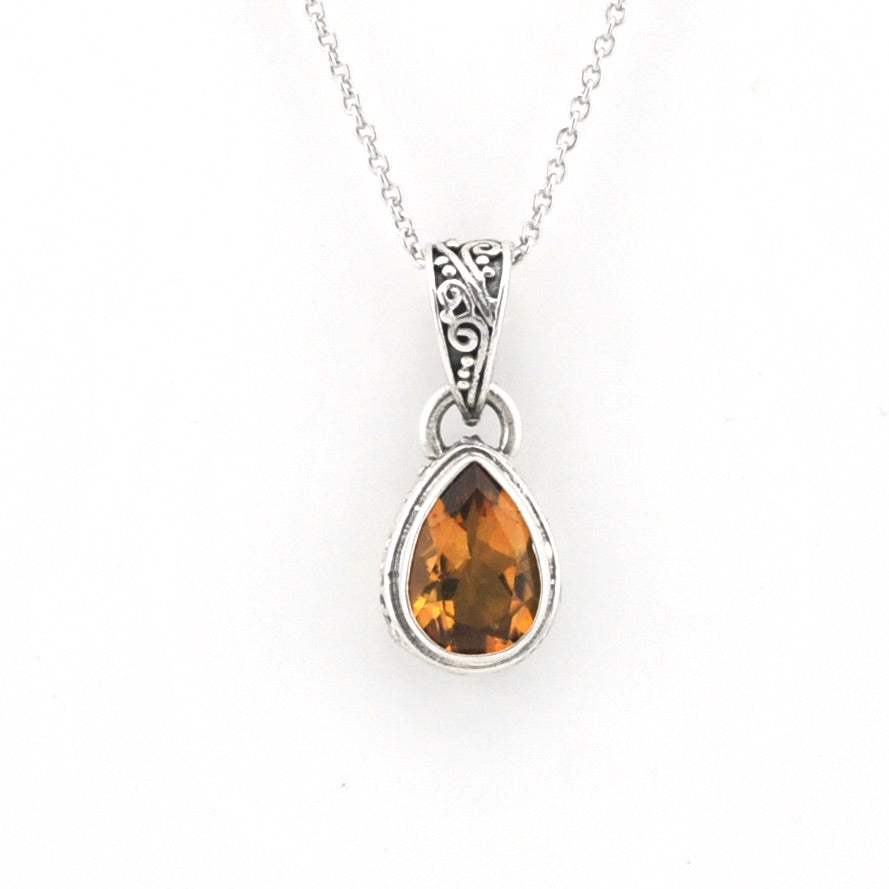 Citrine pendant on silver chain on a white background