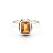 A silver ring featuring a rectangular-cut amber citrine gemstone in a bezel setting, shown against a plain white background.