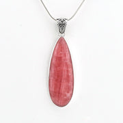 A teardrop-shaped pink gemstone pendant in a silver bezel setting on a silver chain, shown against a plain white background.