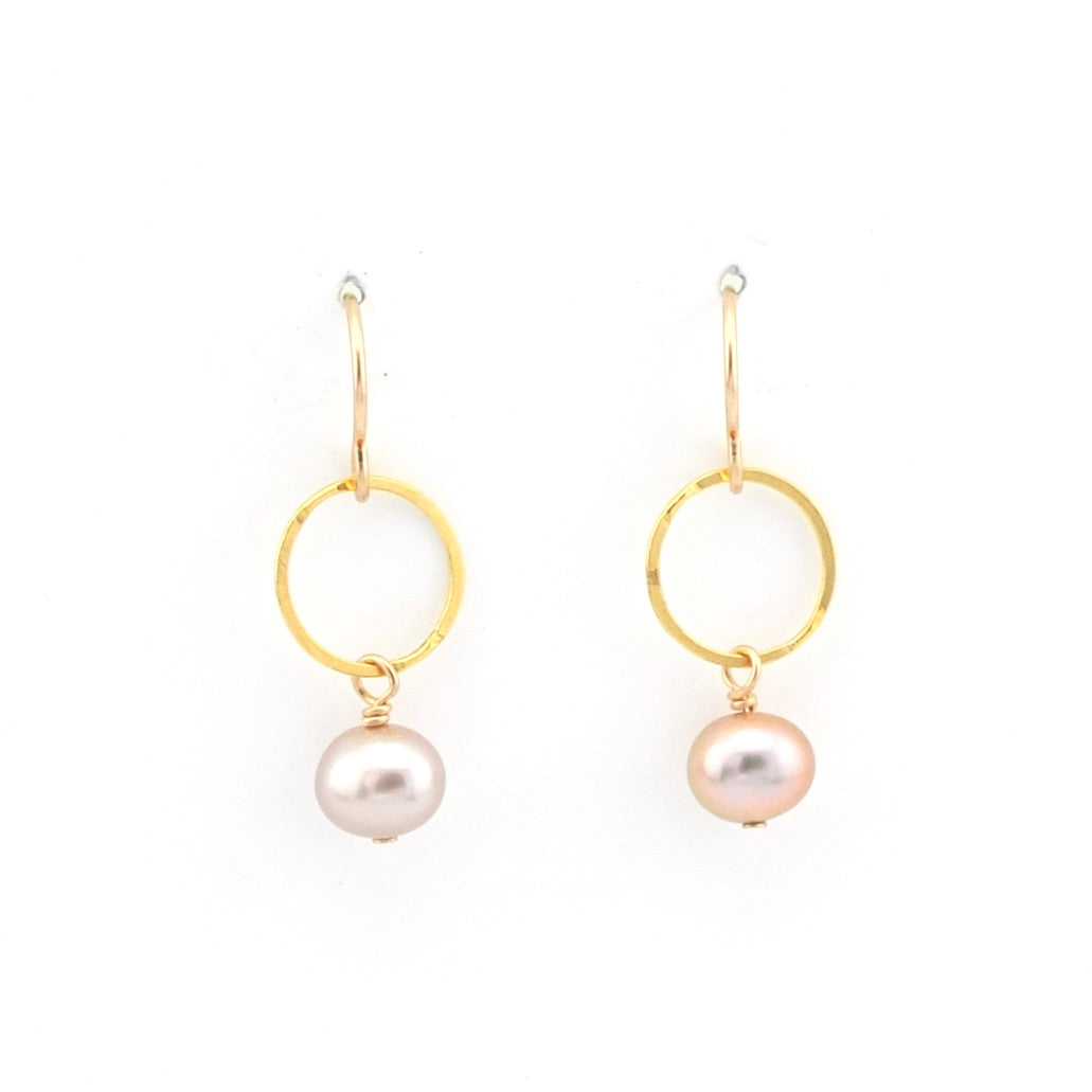 Gold hoop earrings with pearl drops on a white background