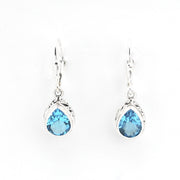 Pair of silver earrings with blue teardrop-shaped gemstones on a white background