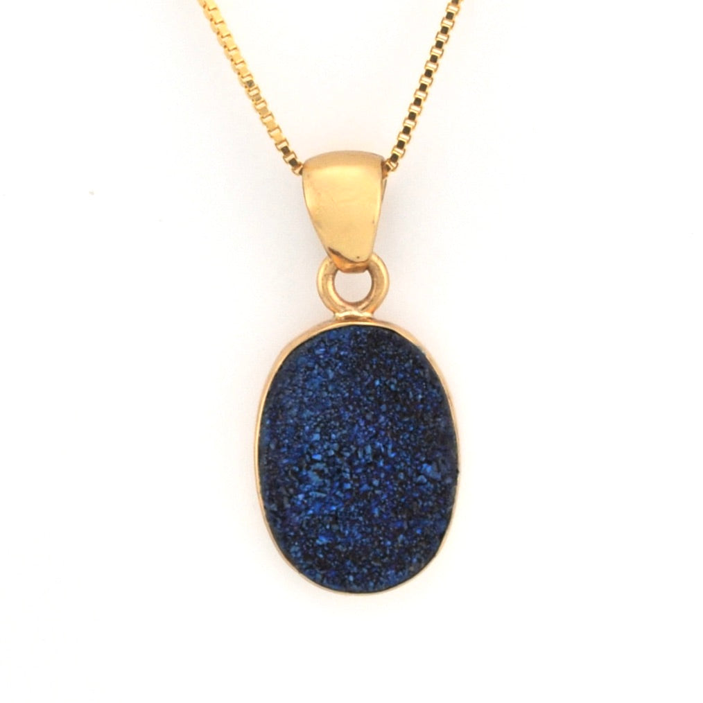 Gold necklace with a blue pendant on a white background