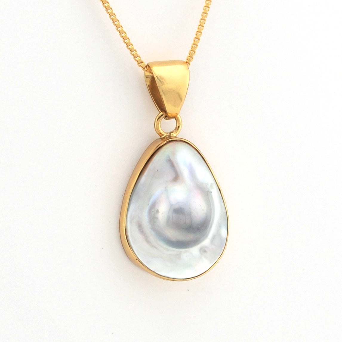 Gold necklace with a teardrop-shaped pearl pendant on a white background