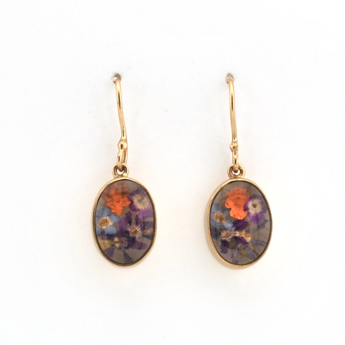 Gold earrings with floral designs on a white background