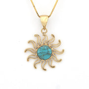 Gold sun-shaped pendant with turquoise center on a white background