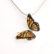 Butterfly-shaped pendant on a chain against a white background