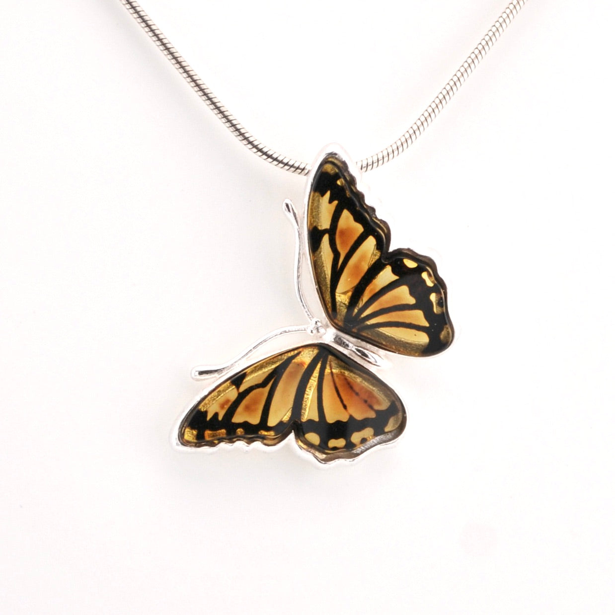Butterfly-shaped pendant on a chain against a white background