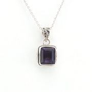 Silver necklace with a purple gemstone pendant on a white background
