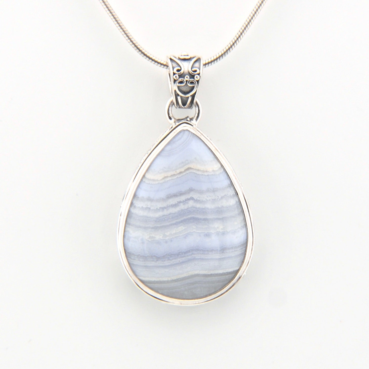 Teardrop-shaped pendant with blue and white pattern on a white background