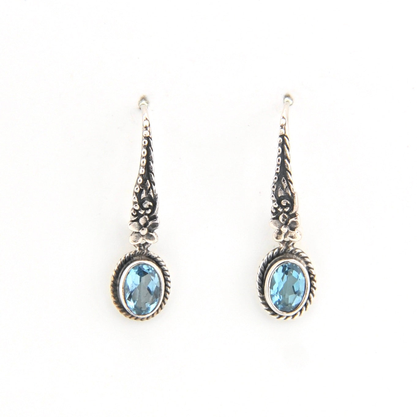 Pair of silver earrings with blue gemstones on a white background