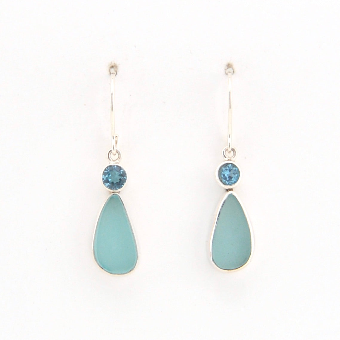 Teardrop-shaped earrings with blue stones on a white background