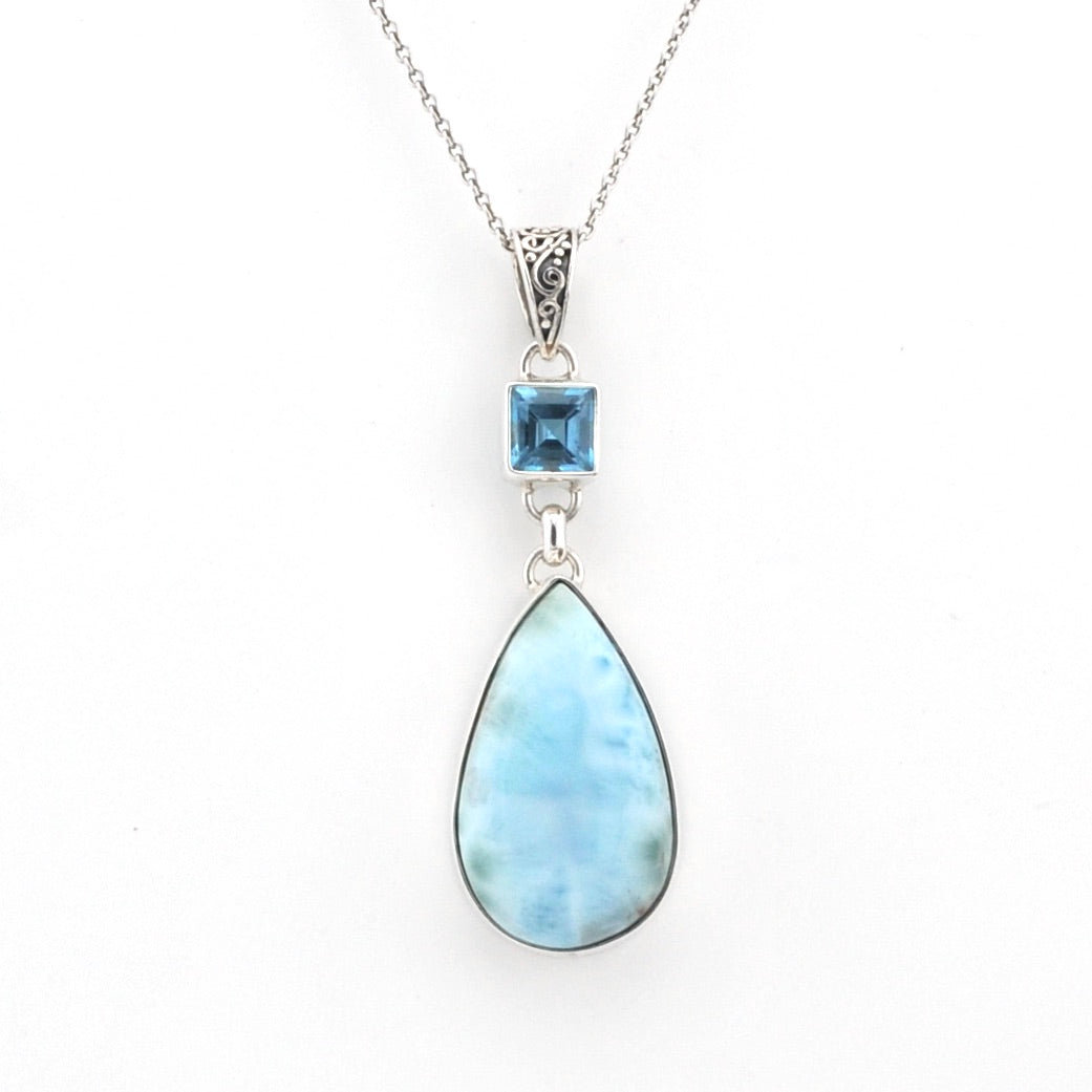 Necklace with a teardrop-shaped blue gemstone pendant on a white background