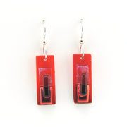 Red rectangular earrings with a central black bar on a white background