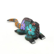 Colorful lizard figurine with floral patterns on a white background