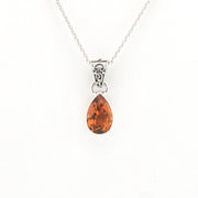 Teardrop-shaped citrine pendant on a silver chain against a white background