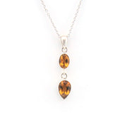 Silver necklace with two citrine teardrop pendants on a white background