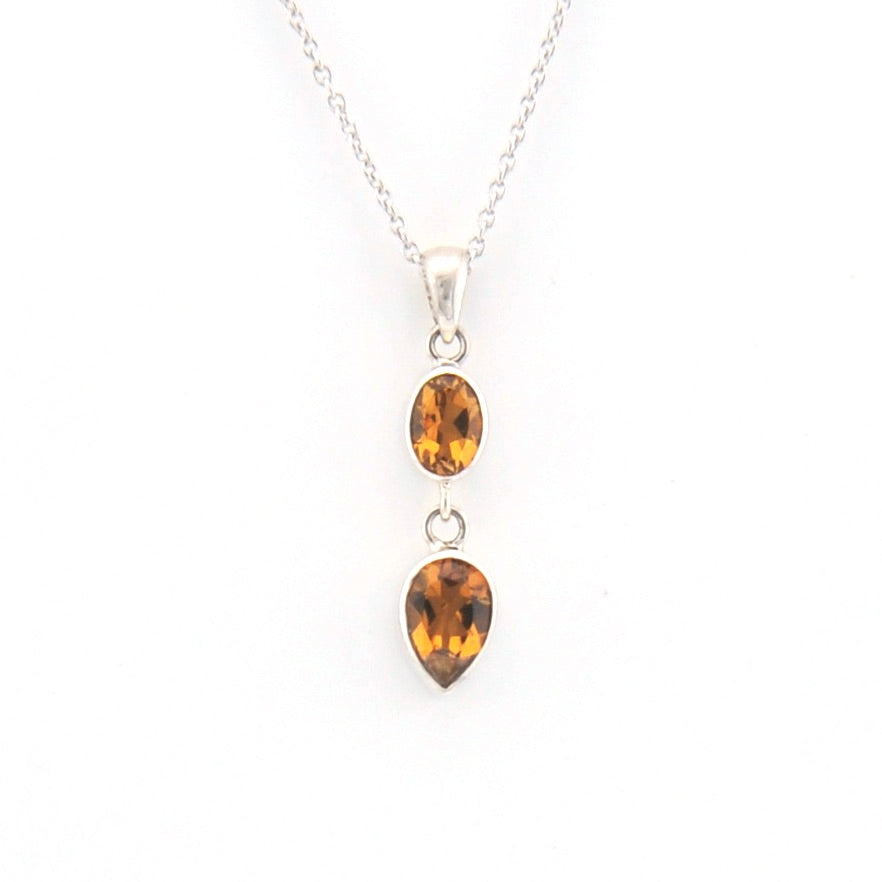 Silver necklace with two citrine teardrop pendants on a white background