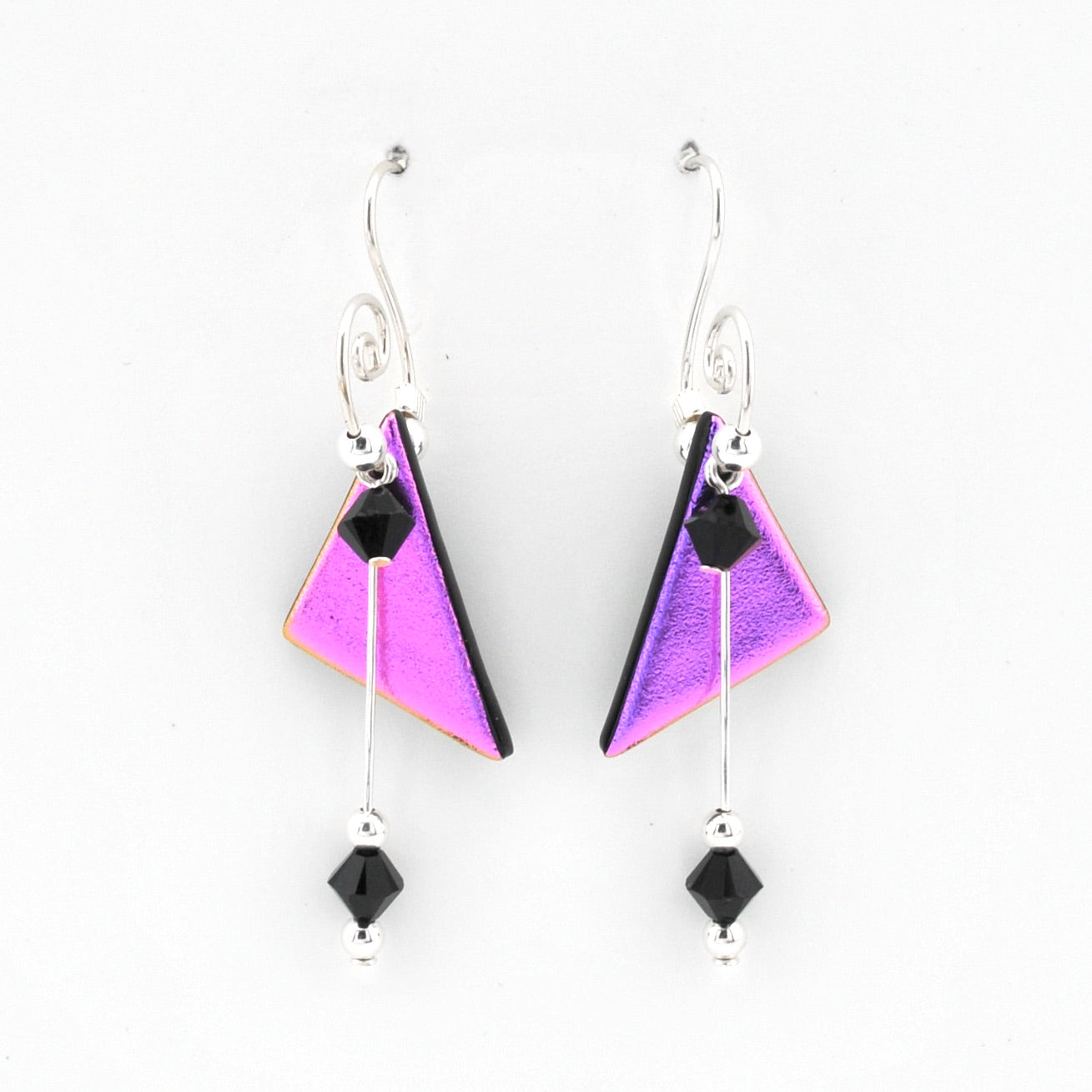 A pair of silver dangle earrings featuring triangular purple and pink iridescent charms with black faceted beads, shown against a plain white background.