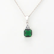 Green gemstone pendant on a silver chain against a white background