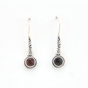 Pair of silver earrings with gemstones on a white background