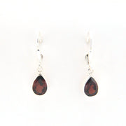 Teardrop-shaped earrings with red stones on a white background