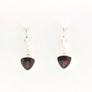 Pair of silver earrings with red gemstones on a white background