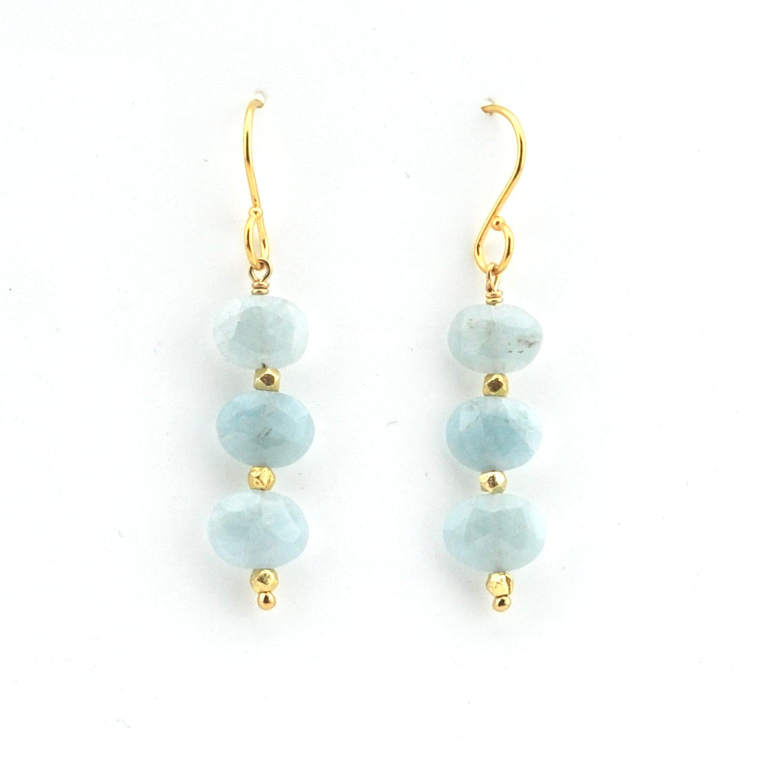 Pair of earrings with light blue beads and gold hooks on a white background