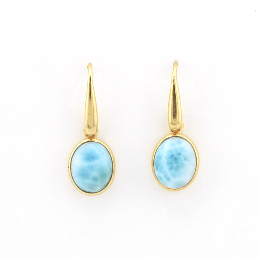 A pair of gold drop earrings with oval light blue marbled gemstone bezels, shown on a plain white background.