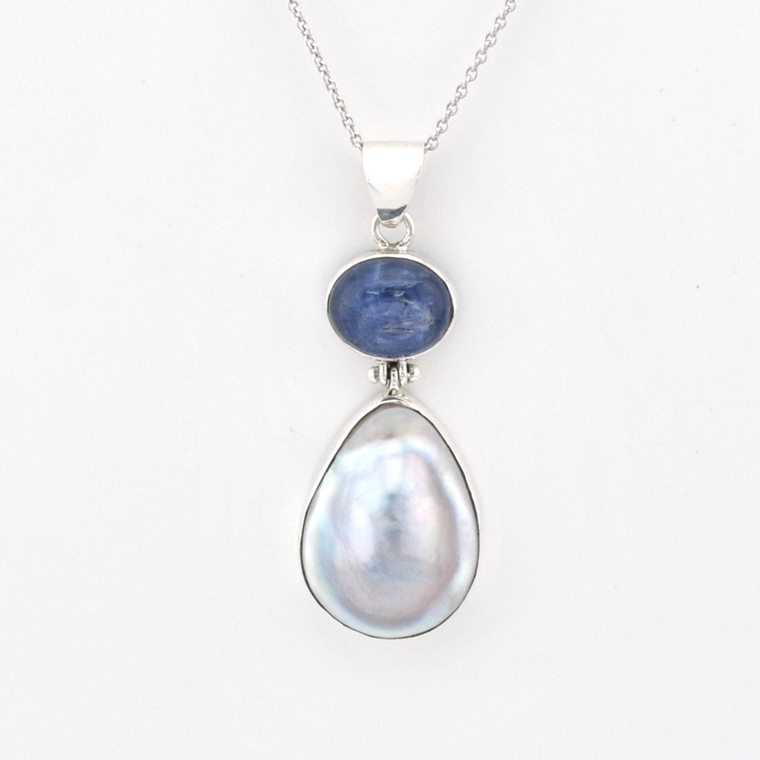 Jewelry with a blue stone and pearl pendant on a white background