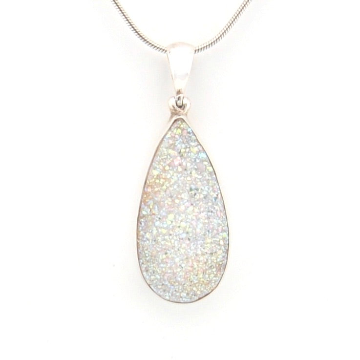 Teardrop-shaped pendant with glittery surface on a white background