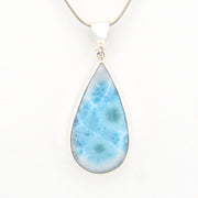Teardrop-shaped larimar pendant on a white background