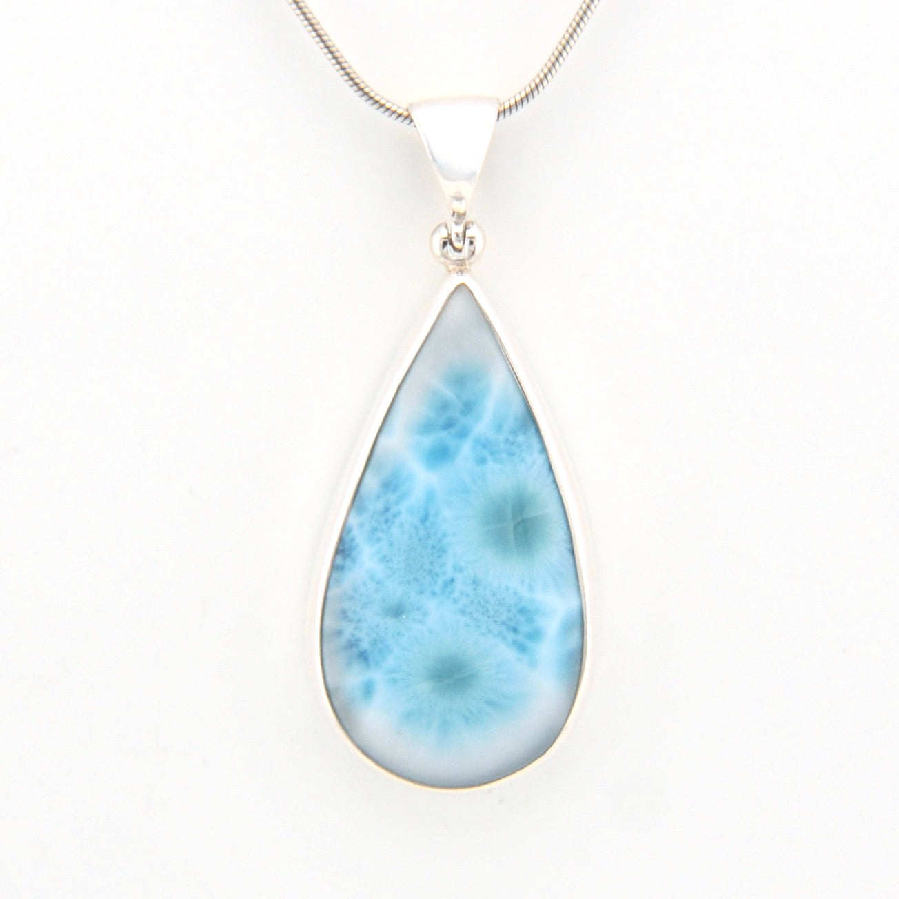 Teardrop-shaped larimar pendant on a white background