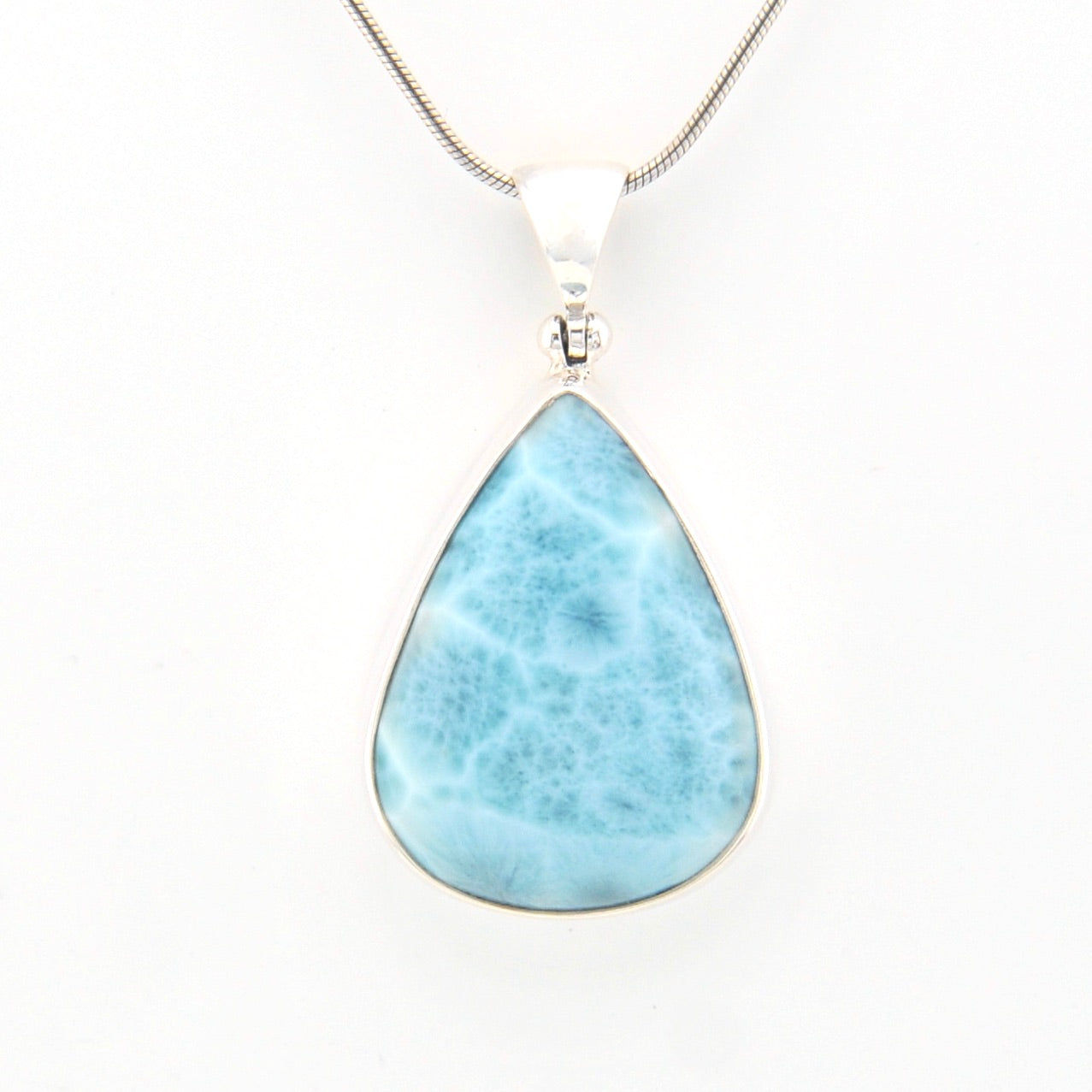 Teardrop-shaped larimar pendant on a silver chain against a white background